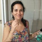 Refugio Luminoso mujer sonriendo en casa, cuidando su bienestar y promoviendo energía positiva.